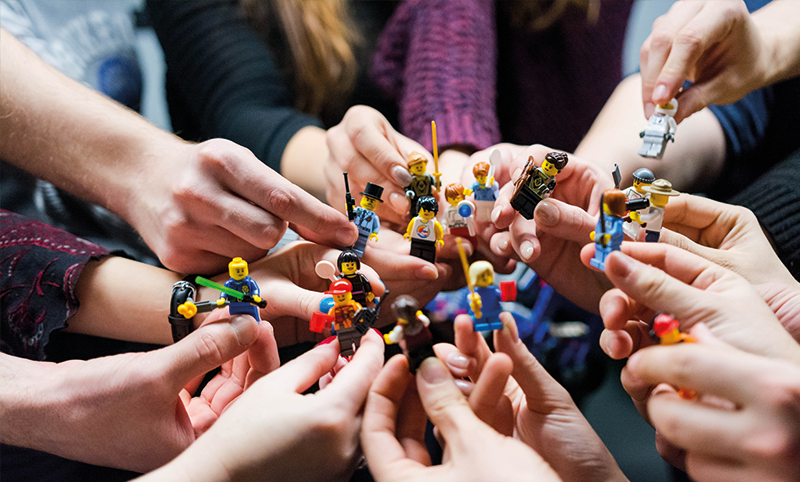 groupe de personnes avec des legos en main